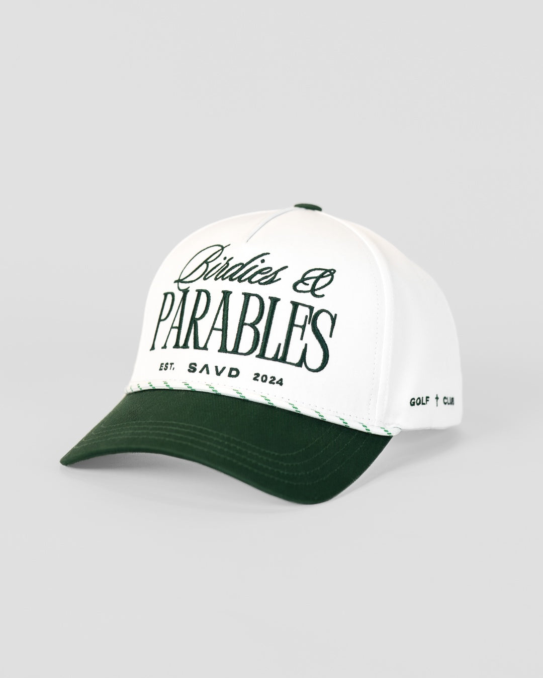 A white and dark green golf cap featuring 'Birdies & PARABLES EST. SAVD 2024' printed on the front, with 'golf cross club' on the side, set against a light gray background.